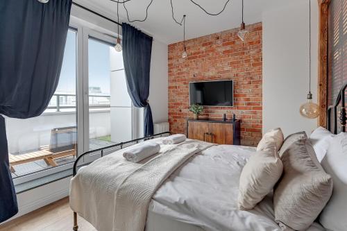 a bedroom with a brick wall and a bed with pillows at Apartament Amber by Q4 Apartments Old Town in Gdańsk