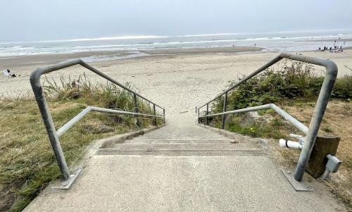 una escalera que conduce a una playa de arena en D Sands Rentals en Lincoln City