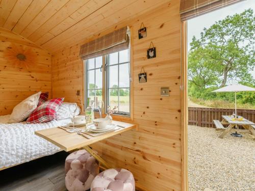 a bedroom in a wooden cabin with a bed and a table at 1 bed in Stapleton 88970 