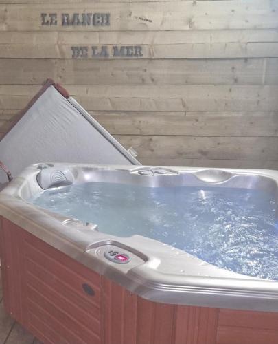 une grande baignoire avec de l'eau à côté d'un mur dans l'établissement le perchoir à côté de la mer ,spa, à Cancale