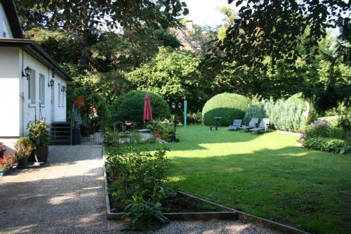 a garden with chairs and an umbrella on the grass at Ferienwohnung am Kurpark in Bad Nenndorf