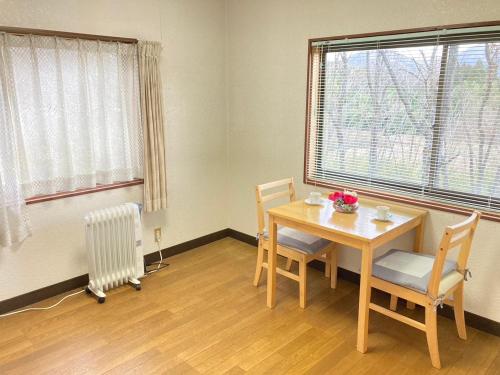 een eetkamer met een tafel en stoelen en een raam bij 雲海と星空の宿 YAKUNO in Fukuchiyama