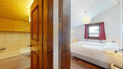 a bedroom with a bed and a sink and a bathroom at Abitaziun Armonia A13 - Celerina in Celerina
