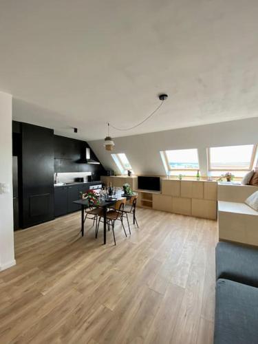 un salon avec une table et des chaises et une cuisine dans l'établissement E centre ville professeur langevin spacieux cosy, à Épernay