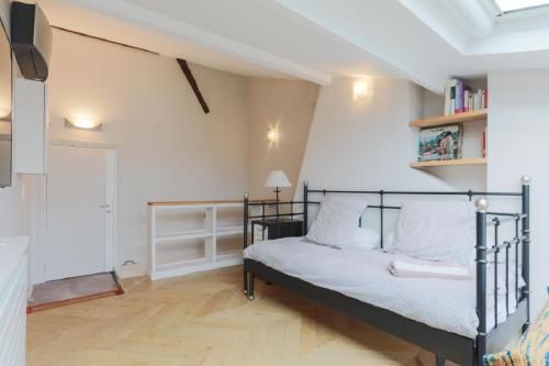 une chambre avec un lit et une étagère dans l'établissement Amazing Mazarine Studio, à Paris