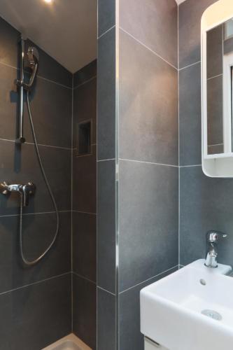 une salle de bain avec douche et lavabo dans l'établissement Amazing Mazarine Studio, à Paris