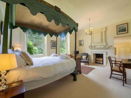 a bedroom with a large canopy bed and a fireplace at 9 Bed in Ingoldisthorpe KT095 in Ingoldisthorpe