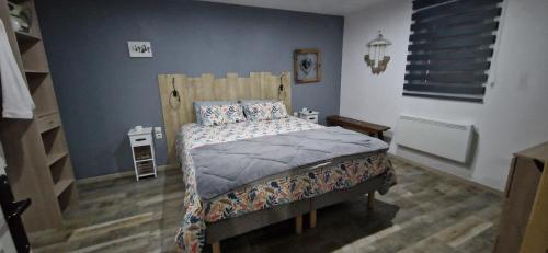 ein Schlafzimmer mit einem Bett mit einem Kopfteil aus Holz in der Unterkunft Atelier d Antoine in Saasenheim