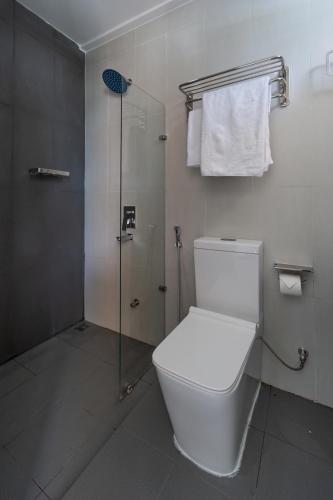 a white bathroom with a shower and a toilet at Silver Oasis Maldives in Huraa