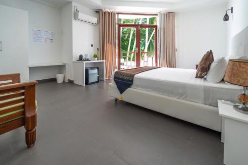 a bedroom with a large bed and a window at Silver Oasis Maldives in Huraa