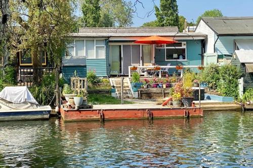 a house on the water with a boat in front at Idyllic Island Cottage with Boat in Hampton