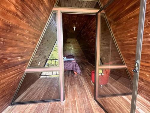 - Vistas interiores a una cabaña de madera con puertas de cristal en Bungalow Tenorio Mountain Lodge, en San Rafael