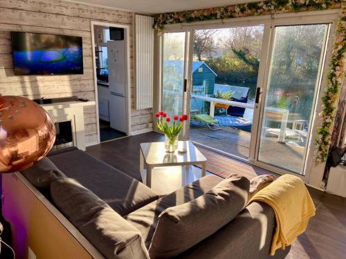 a living room with a couch and a television and a table at Idyllic Island Cottage with Boat in Hampton