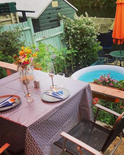 a table with a purple table cloth with flowers on it at Idyllic Island Cottage with Boat in Hampton
