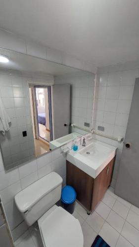 uma casa de banho com um lavatório, um WC e um espelho. em APARTAMENTO CHAPINERO CENTRAL em Bogotá