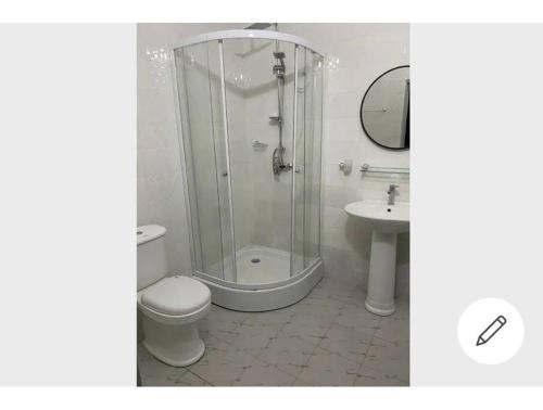 a bathroom with a shower and a toilet and a sink at Studio meublé in Diass