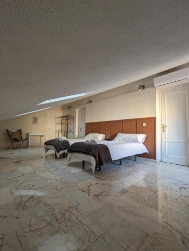 a large bedroom with a bed and a stone floor at Ático San Juan 2 in Cáceres