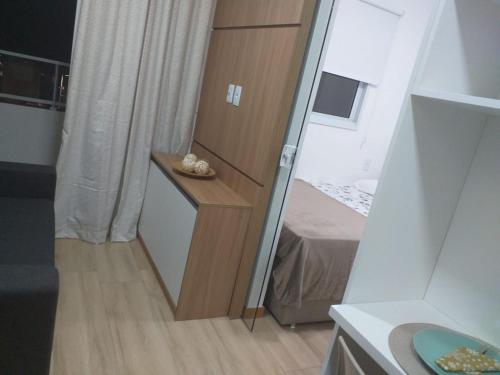 Habitación pequeña con cama y espejo. en APARTAMENTO smart PITUBA 5, en Salvador