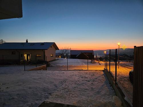 einen Zaun vor einem Haus im Schnee in der Unterkunft Veselé Apartmány Lipno in Lipno nad Vltavou