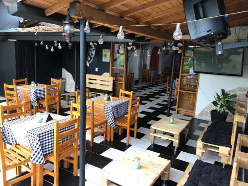 un restaurante con mesas de madera y sillas en un suelo a cuadros en Aqua Lux, en Medellín
