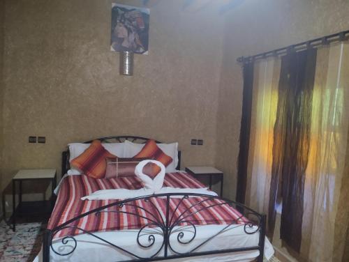 a bedroom with a bed with a white swan on it at El Menzeh Foundation in Rissani