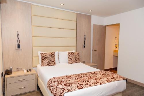 1 dormitorio con 1 cama grande y mesita de noche en Hotel Laureles Loft en Medellín