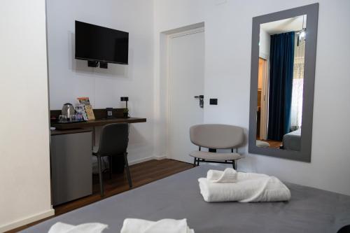 a room with a bed with a desk and a mirror at Guest House Al Viale in Caltagirone