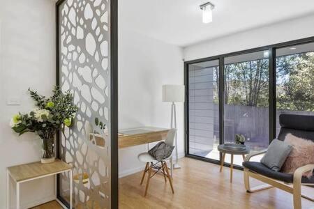 a living room with a couch and a table and a desk at New Architect designed Coastal retreat-water views in Hobart