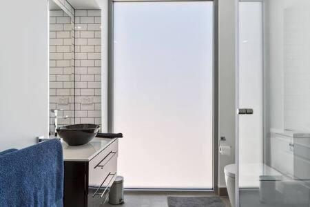 a kitchen with a large glass door with a bowl on a counter at New Architect designed Coastal retreat-water views in Hobart