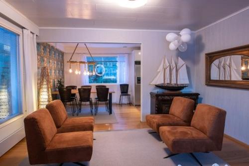 a living room with two chairs and a dining room at Villa Närhi 230 m2 upea talo rauhallisella alueella in Seinäjoki