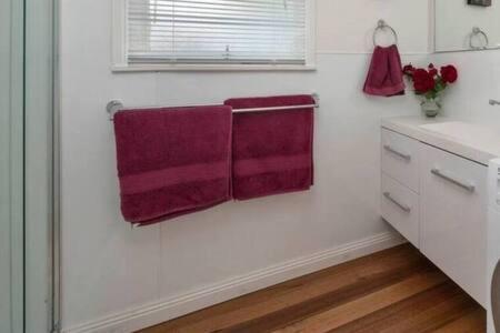 two burgundy towels hanging on a wall in a kitchen at The Baker's Cottage in the Heart of Richmond Sleeps 6 in Hobart