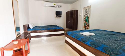 a room with two beds and a desk and a table at Ocean front beach resort in Tajpur