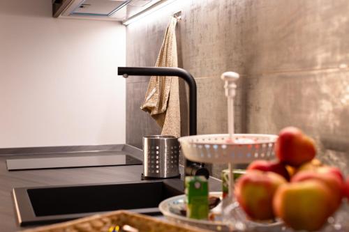 una encimera de cocina con manzanas en un tazón y un fregadero en Guest House Al Viale, en Caltagirone