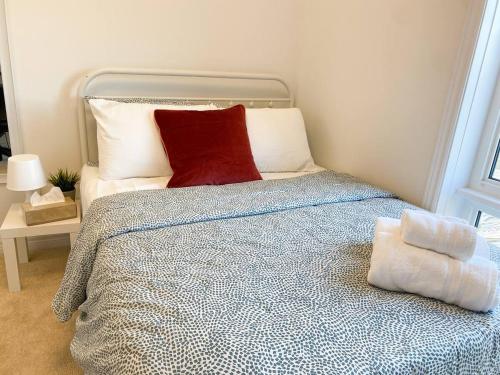 Un dormitorio con una cama con una almohada roja. en Dockside Relaxing Private Bedroom,, en Whitby