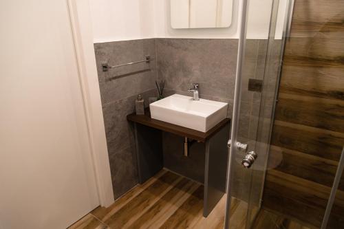 a small bathroom with a sink and a shower at Guest House Al Viale in Caltagirone