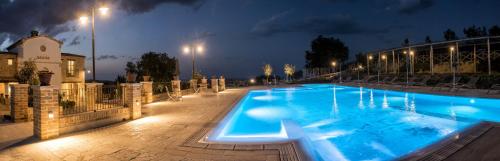 a large blue swimming pool at night with lights at Villa Sant'Angelo in Alba Adriatica