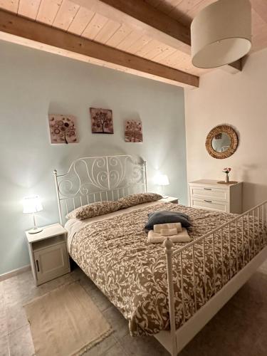 a bedroom with a bed with a metal bed frame at Affittacamere Il Cortile in Chiaravalle