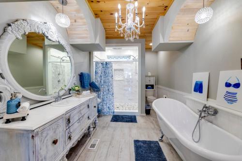 een badkamer met een bad, een wastafel en een spiegel bij Grand Lake Escape: Serenity Meets Space in Talladega