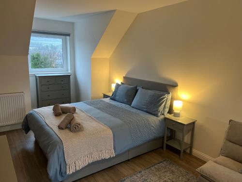 ein Schlafzimmer mit einem Bett mit einem Teddybär drauf in der Unterkunft Inchmurrin Townhouse, Loch Lomond in Bonhill