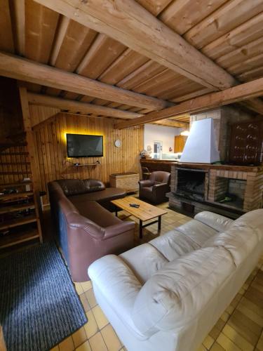 a living room with a white couch and a fireplace at Chata pri Veľkej Rači in Oščadnica