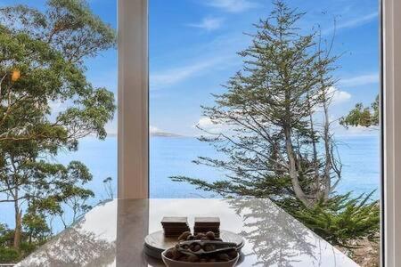 a table with two chairs and a view of the ocean at Hidden Bay Retreat-5 Bed- 15min to Hobart in Hobart