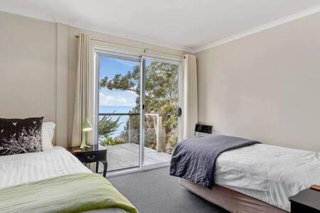 Hidden Bay Retreat-5 Bed- 15min to Hobart في هوبارت: غرفة نوم مع سرير وإطلالة على المحيط