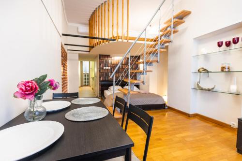 uma sala de jantar com uma mesa e cadeiras e uma escadaria em VINTAGE SENACKA APARTMENTS em Cracóvia
