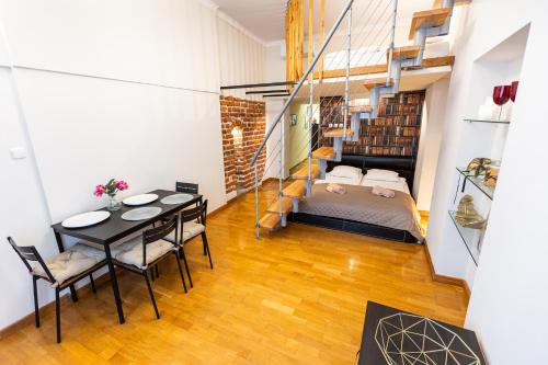 um quarto com uma cama, uma mesa e cadeiras em VINTAGE SENACKA APARTMENTS em Cracóvia