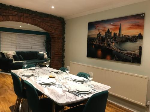 uma sala de jantar com uma mesa com copos de vinho em Woodland Green - BHX, NEC, HS2 em Marston Green