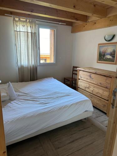 - une chambre avec un grand lit et une fenêtre dans l'établissement Appartement T3+Mezzanine Augustine, à Courchevel