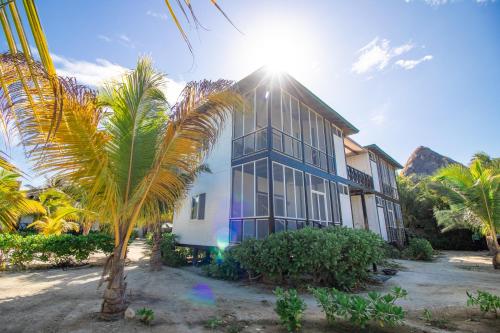 dom z palmą przed nim w obiekcie Villas El Encanto Holbox w mieście Isla Holbox