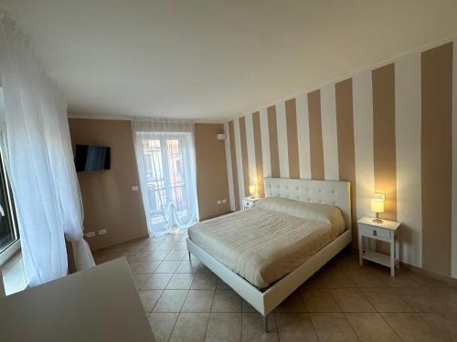 a bedroom with a bed and a striped wall at Terrazza su Tocco in Tocco da Casauria