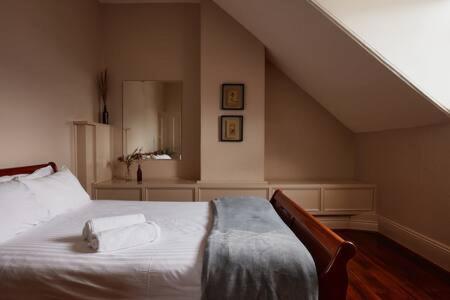 ein Schlafzimmer mit einem Bett mit zwei Handtüchern darauf in der Unterkunft Historic Home close to CBD 3Brm with views in Hobart