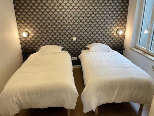 2 letti posti uno accanto all'altro in una camera da letto di Séjour de charme au marais bleu a Amboise